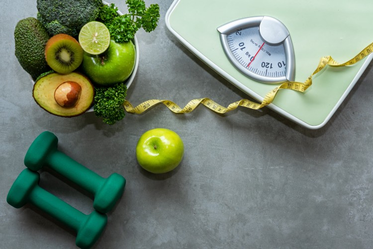 Healthy lifestyle green eating, a weight scale, and hand weights for weight loss